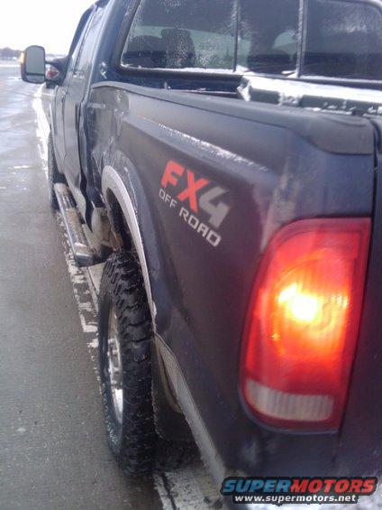2005 Ford F-250 pickup truck rear quarter panel with FX4 Off Road decal and illuminated taillight