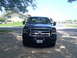 2005 Ford F-250 - A dark blue Ford F-250 is parked in front of a house on a sunny day.