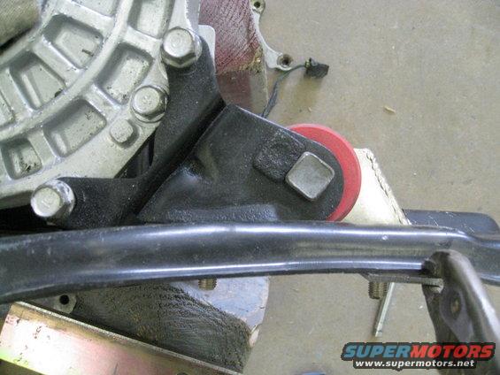 Close-up of an engine mount with a red bushing and metal bracket