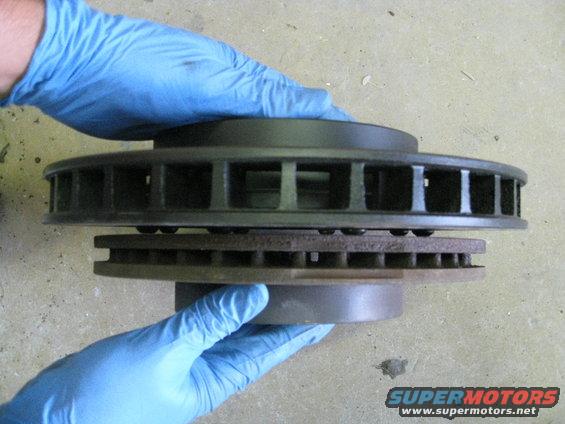 Two brake rotors held by gloved hands