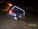 1986 Ford Bronco - A red and white Ford Bronco is seen off-roading at night, stuck in mud.