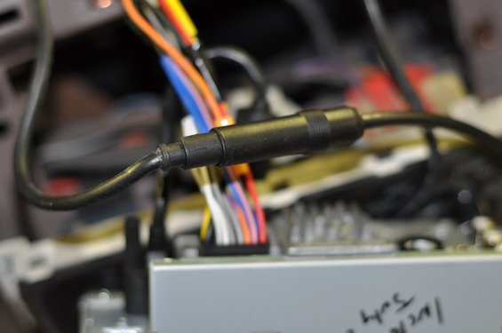 Close-up of a black connector on a wiring harness with colorful wires
