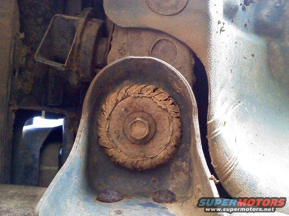 Close-up of a rusty suspension part with a bolt in the center