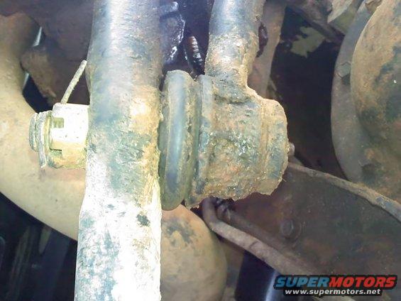 close-up of rusty suspension parts with a rubber bushing