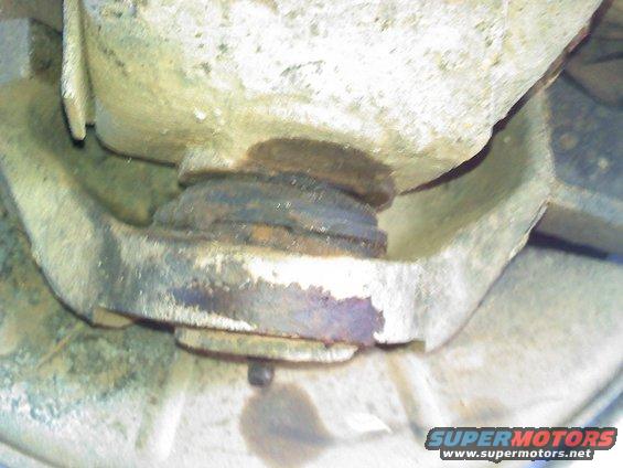 Close-up of a rusty suspension component with a Supermotors.net watermark