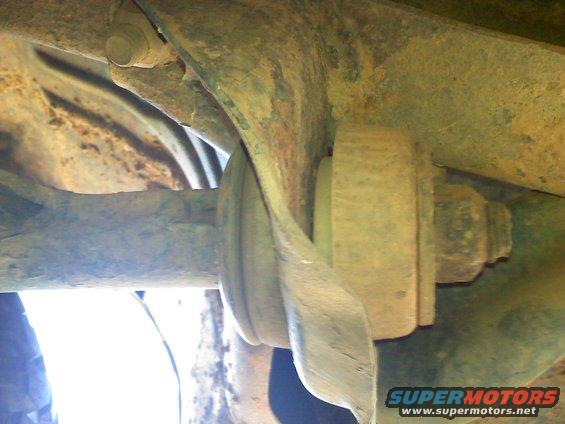 Close-up of a rusty suspension bushing and bolt on a vehicle's undercarriage