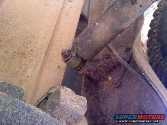 Close-up of a rusted suspension component, possibly a shock absorber mount