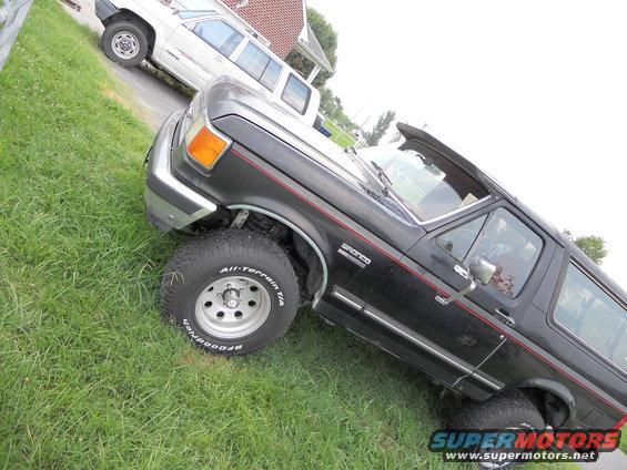 1988 Ford Bronco parked on grass with another SUV behind it