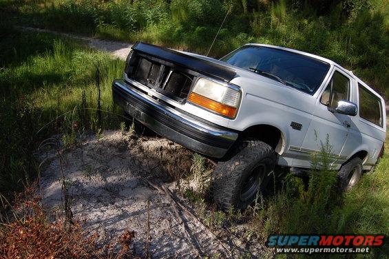 1994 Ford Bronco on dirt path with tall grass