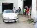 2004 Mercury Marauder - A white sedan with a red stripe and hood scoops is parked outside a garage with several people standing nearby.