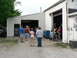 2004 Mercury Marauder - People are gathered outside a garage, with some looking inside the open bay door.