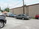 2004 Mercury Marauder - Several vehicles are parked in a lot, including a gray coupe and a blue coupe with its hood open.
