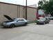 2004 Mercury Marauder - Two Ford Thunderbirds are parked outside a building, one with its hood up.