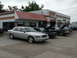 2004 Mercury Marauder - A silver sedan is parked in front of a Speedy Discount Mufflers & Brakes shop, with several other vehicles visible.