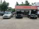 2004 Mercury Marauder - A silver 2004 Mercury Marauder is parked in front of a shop with its hood open, alongside two other vehicles.