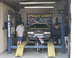 2004 Mercury Marauder - A gray sedan is positioned on a car lift inside a garage, with a "SPEEDY DYNO" banner visible in the background.
