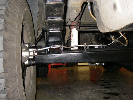 Undercarriage view of a vehicle's rear axle, brake caliper, and suspension components
