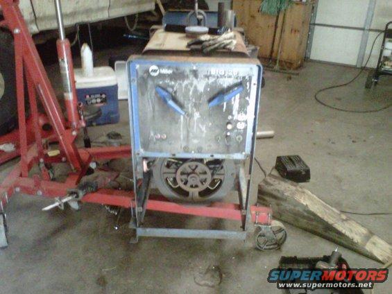 Welding machine with blue accents and a fan, on a metal cart with wheels