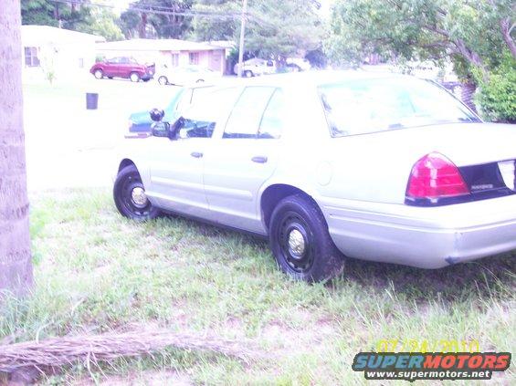 2003 Ford Crown Victoria police car parked on grass, side view