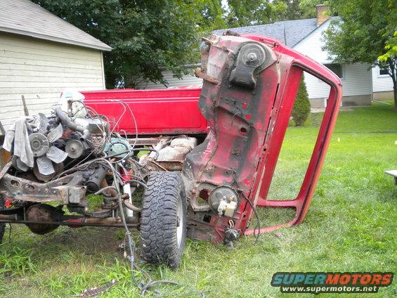 Red 1985 Chevrolet C/K Pickup chassis with engine exposed, viewed from 3/4 front
