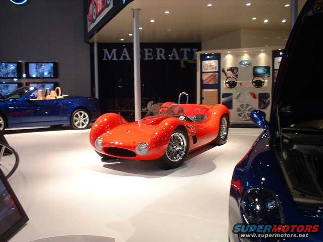 Red vintage sports car with exposed wheels and a low profile, viewed from the front