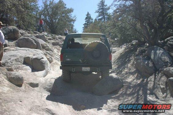 Green 1991 Ford Bronco on rocky trail, rear view
