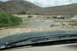 1995 Ford Bronco - Off-road vehicles gathered by a river in a dry, hilly landscape.
