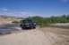 1995 Ford Bronco - A 1995 Ford F-150 navigates a sandy riverbed under a clear blue sky.