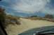1995 Ford Bronco - Driving on a rough dirt road through a dry, brushy landscape towards a distant mountain.