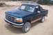 1995 Ford Bronco - Dark teal 1995 Ford Bronco with tan trim and spare tire visible in rear.