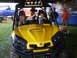 2003 Yamaha RAPTOR 80 - A yellow ATV with a black roll cage is parked outdoors with two girls inside.