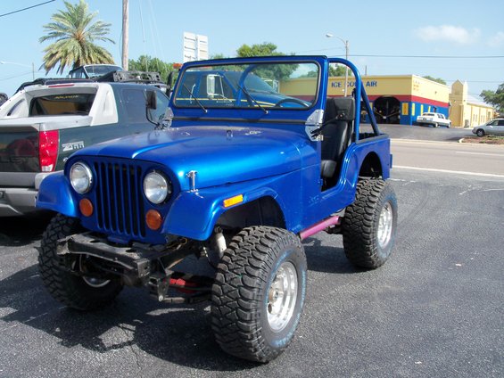 Blue 1978 Jeep CJ5 with off-road tires and roll cage