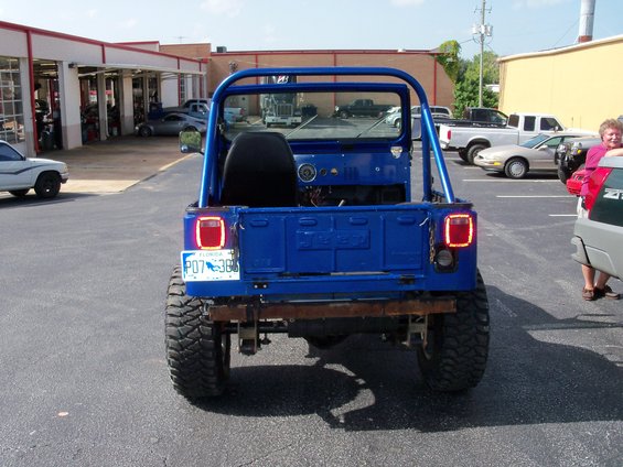Blue 1978 Jeep CJ5 with a roll cage, rear view, Florida license plate P07 386, and aftermarket bumper