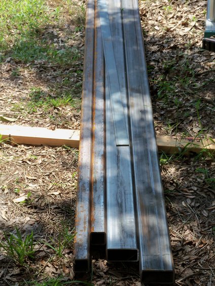 Several lengths of steel tubing stacked on the ground