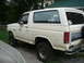 1985 Ford Bronco - Side view of a white 1985 Ford Bronco with stickers on the rear window.