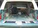 1989 Ford Bronco - The interior and cargo area of a 1989 Ford Bronco are visible, showing a stripped-down condition.