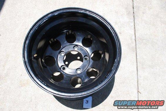 Black off-road wheel with 5 lug holes and a valve stem