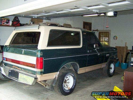 Green and tan 1989 Ford Bronco parked in a garage