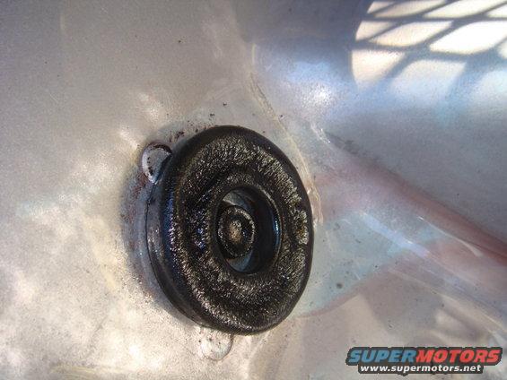 Black rubber grommet with bolt head, close-up view