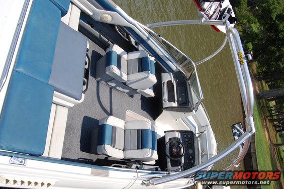 Boat interior with blue and gray seats, steering wheel, and dashboard
