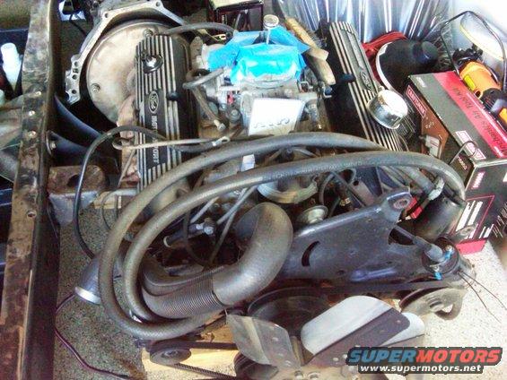 Ford Motorsport valve covers on an engine assembly with hoses and carburetor