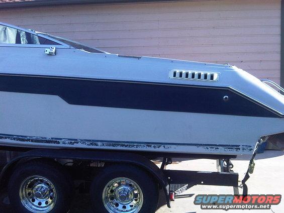 Side view of a white and blue boat on a trailer