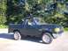 1990 Ford Bronco - A dark green 1990 Ford Bronco is parked outdoors on a sunny day.