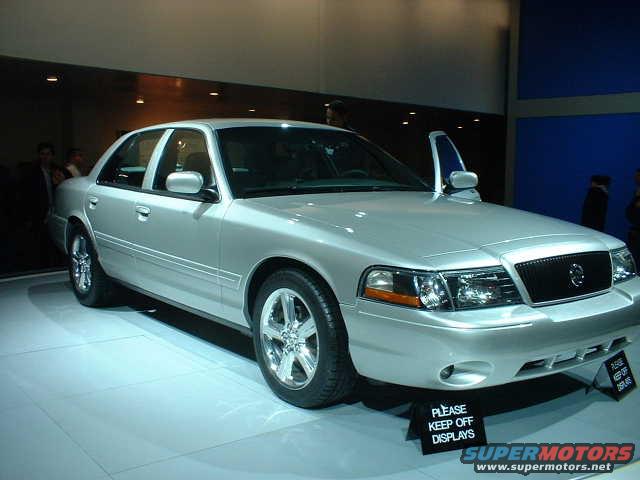 Silver sedan with chrome wheels and a black grille, viewed from the front three-quarter angle