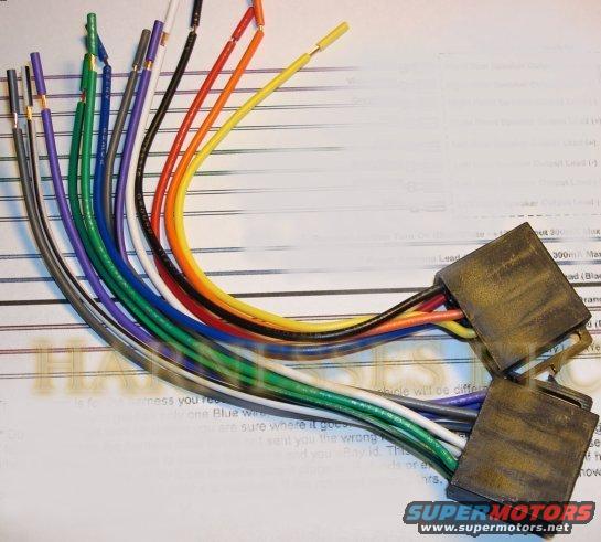 Wiring harness with multiple colored wires and two black connectors on top of a document