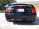 1970 Mercury Cougar - Rear view of a black Ford Mustang GT convertible with a Texas license plate and aftermarket spoiler.