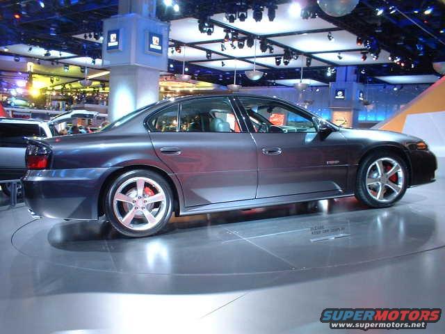 Dark sedan side view on display floor with red brake calipers