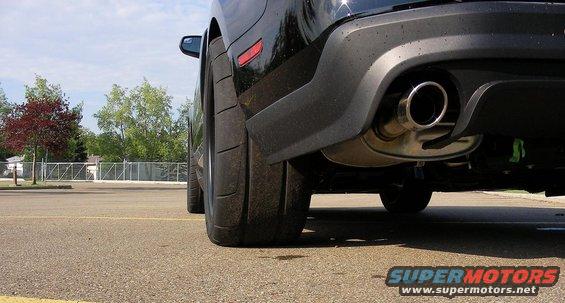 Rear tire and exhaust of a black 2011 Ford Mustang