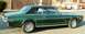 1968 Mercury Cougar - A green 1968 Mercury Cougar coupe with a black vinyl roof is parked outdoors, with other vehicles in the background.