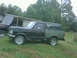 1990 Ford Bronco - This 1990 Ford Bronco is parked on a grassy area next to a building with a tarp covering part of its roof.